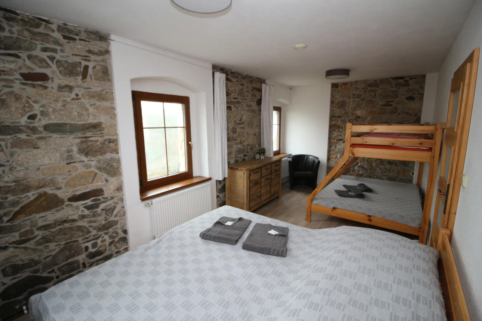 Apartmán Šutrs – ložnice s kamennou zdí