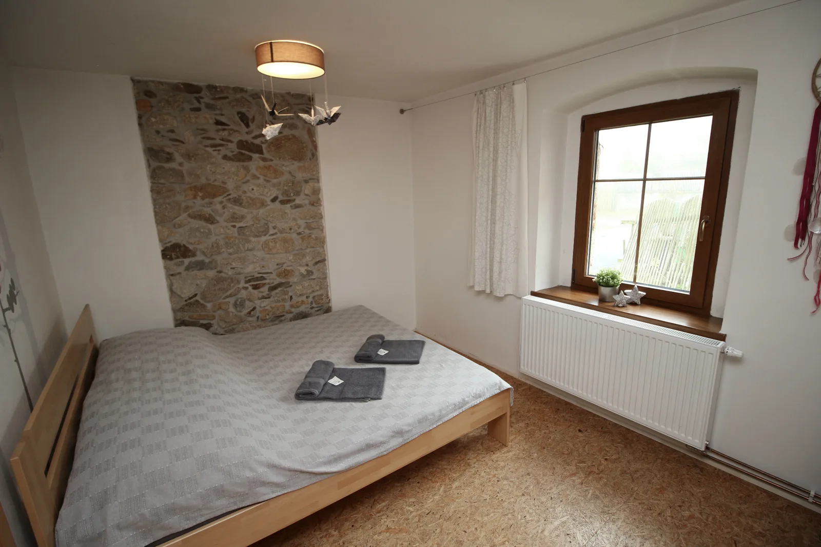 Apartmán Marzebill – ložnice s kamennou zdí